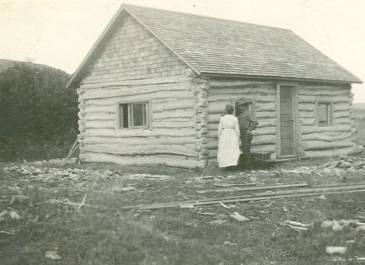 McKenzie County 1915 -  Pioneer Museum of McKenzie County Collection - Couple inspecting log house