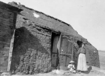 Morton County 1905 - Sig Peterson Photograph Collection - Woman and child in front of sod house
