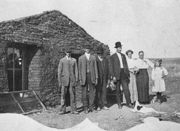 Rolette County Ox Creek - Mr. and Mrs. Joseph Strand and family in front of their sod house, probably at Ox Creek, Rolette County