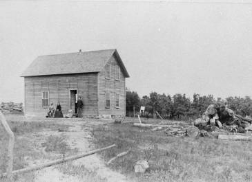 People outside two story wood frame house